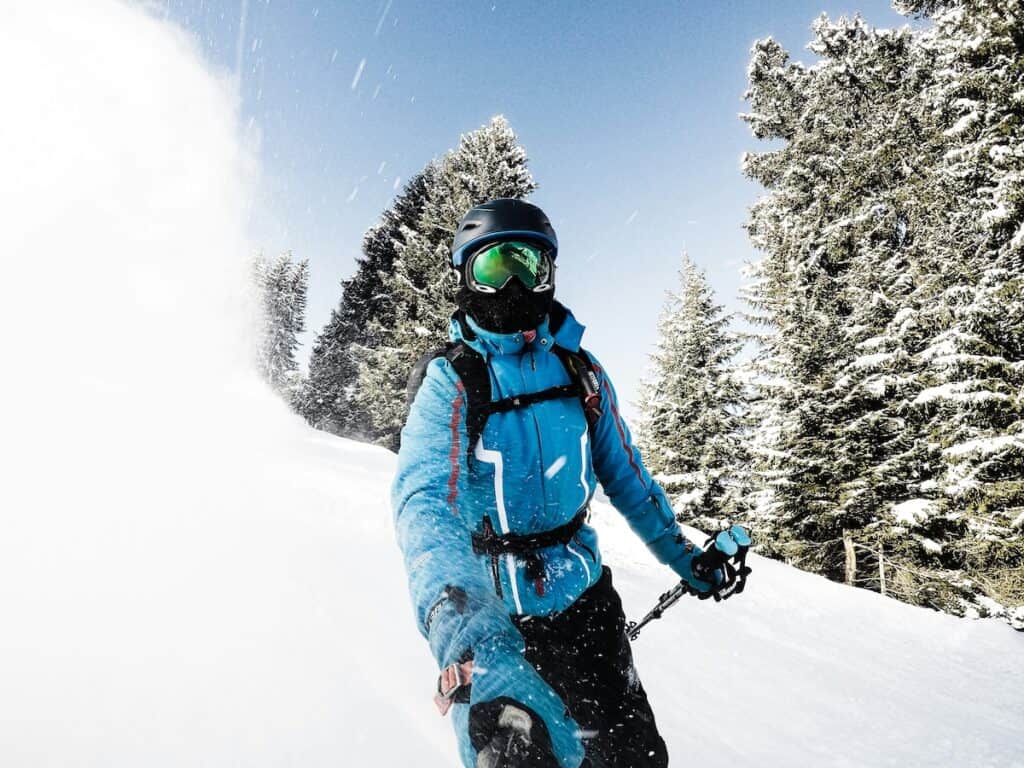 A skier wearing one of the best gaiters for skiing while going fast down the slopes.