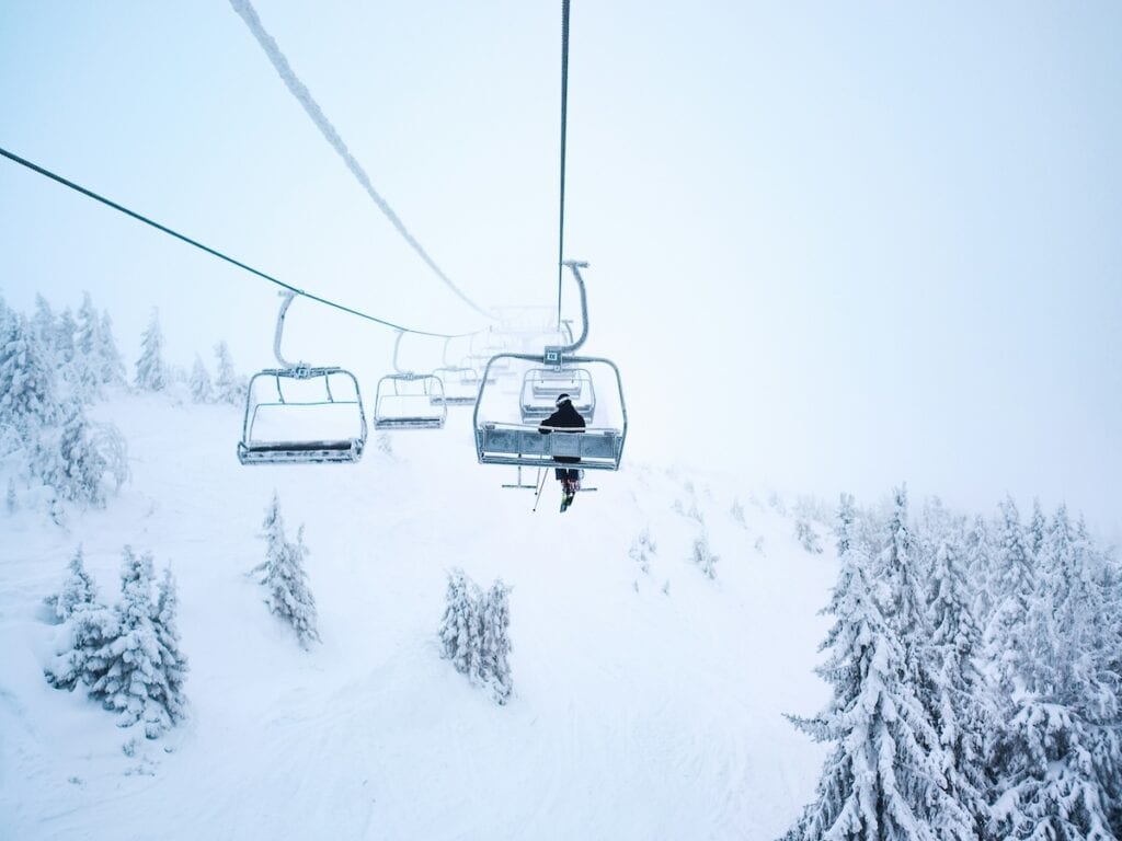 A skier sitting alone on a lift.