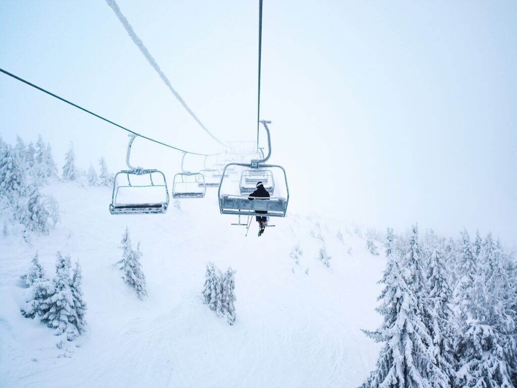 A skier sitting along on a lift.