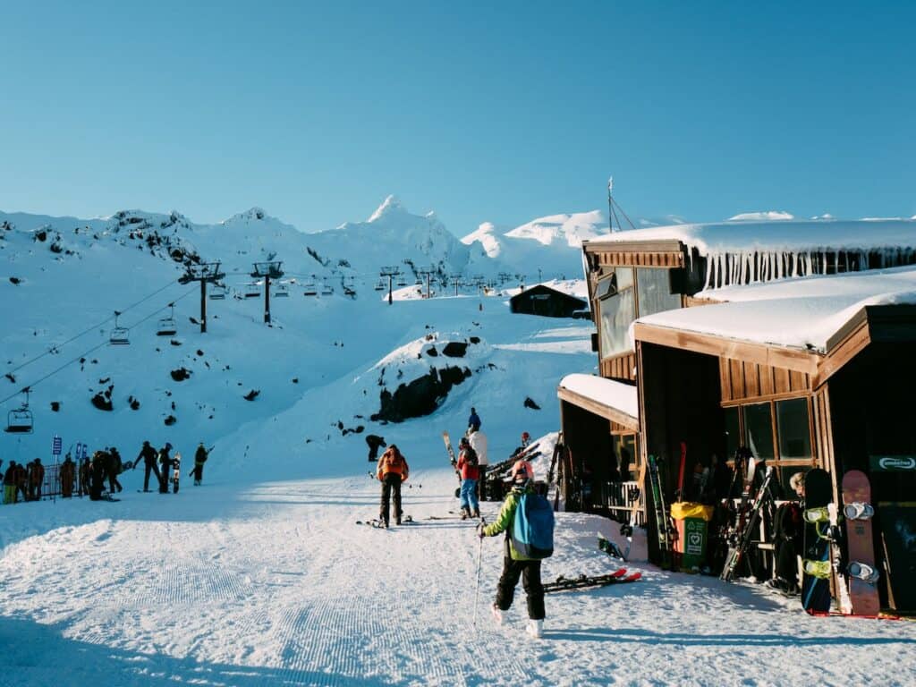 A ski resort with a lodge, skiers, and lift.