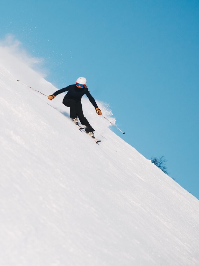 A woman skiing down a sharp ski slope.
