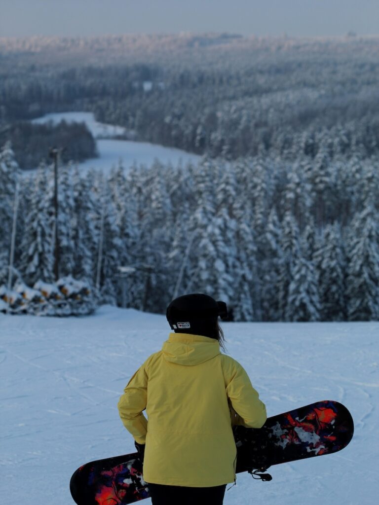 A snowboarder carrying their board.