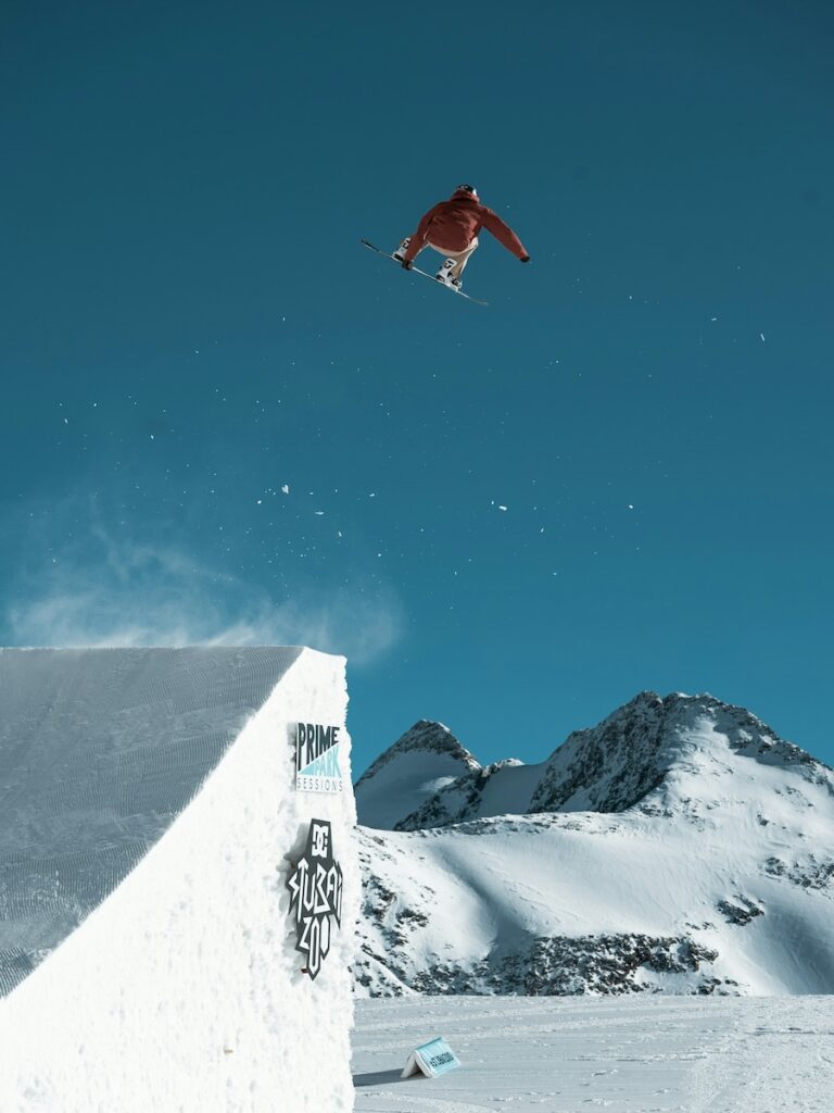 A snowboarder jumping high off a jump.