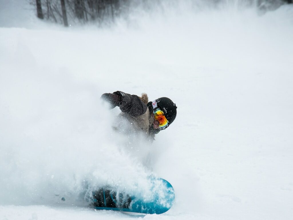A snowboarder spraying snow.