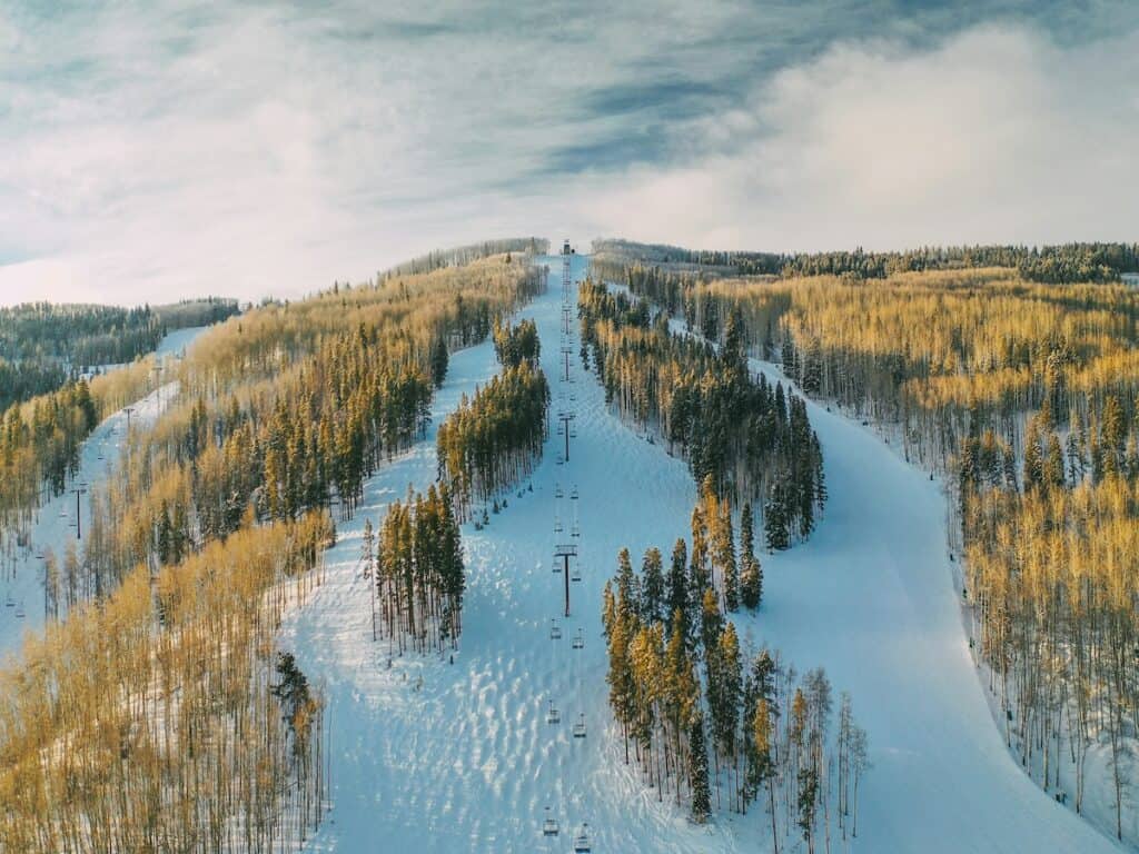 An aerial view of ski slopes and a lift.