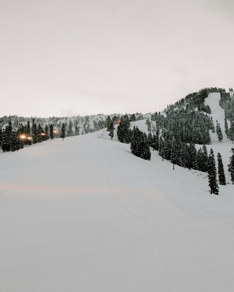 A ski slope covered in snow during the evening.