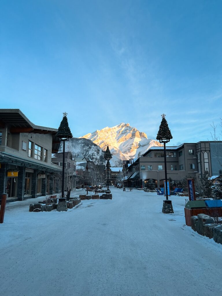 The charming downtown area at Banff with a mountain off in the distance and blue skies above.