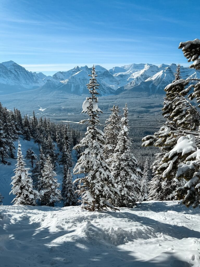 Blue skies and surrounding mountains from on top of a ski resort from on top one of the best ski resorts to visit in April.