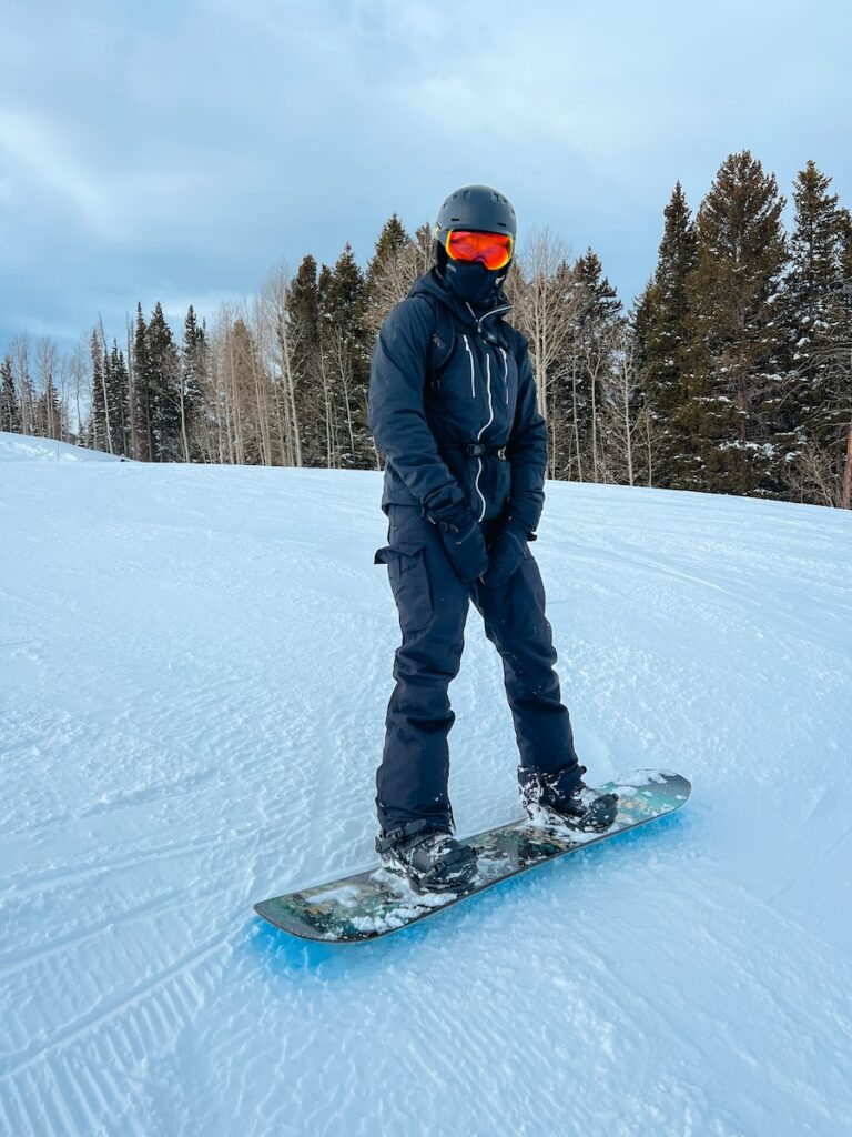 Sam strapped into his snowboard at a ski resort in Utah.