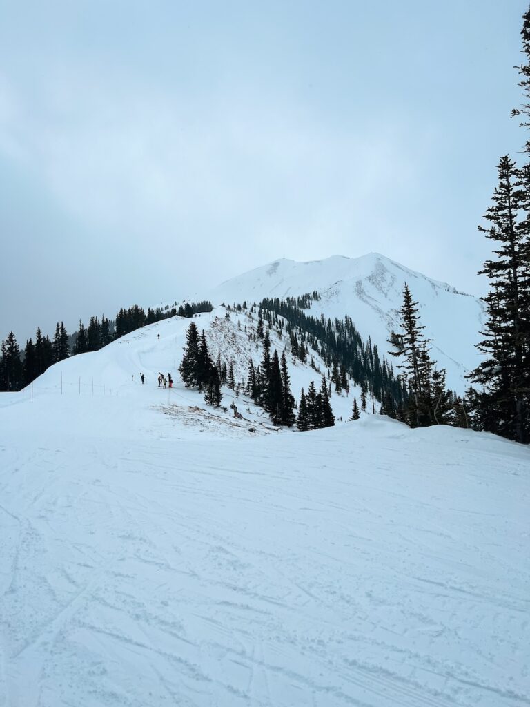 Skiers starting to hike up a mountain in Aspen for an epic run.