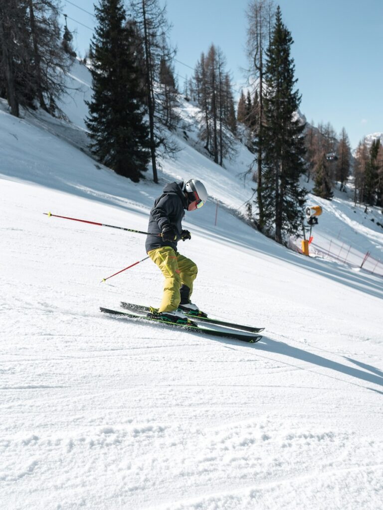 A skier going down the mountain in green pants.
