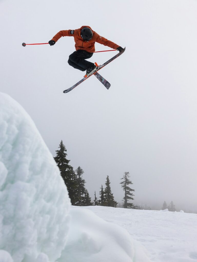 A skier jumping in his boots and skis.