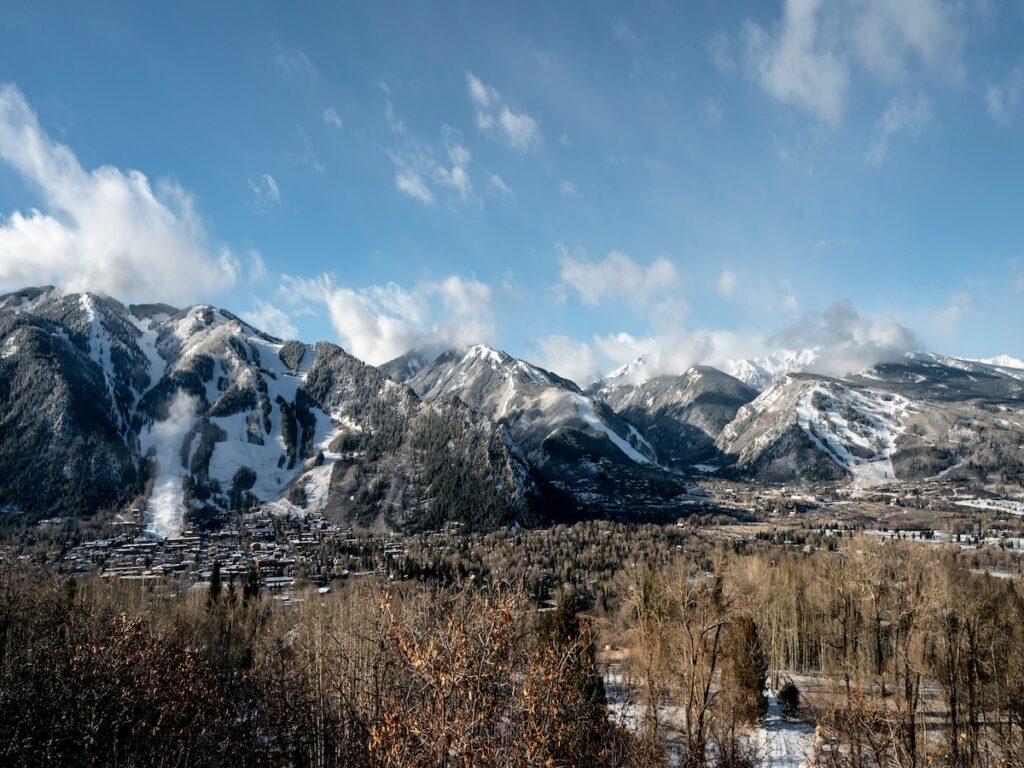 Aspen ski mountains with blue skies above.