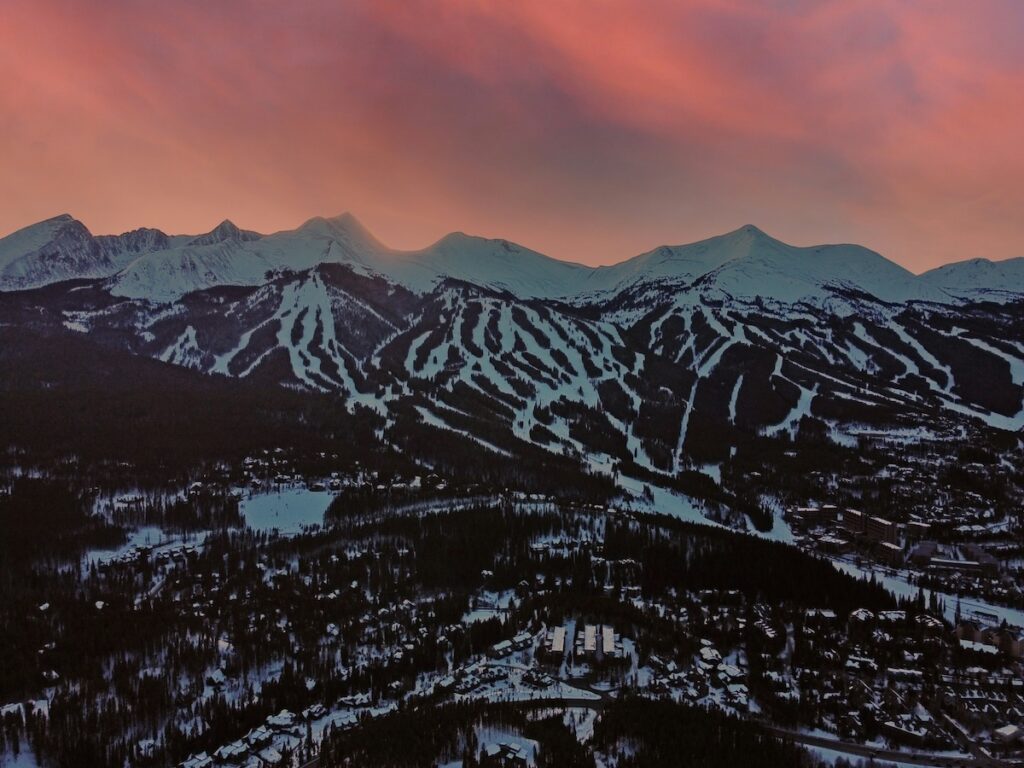 Breckenridge ski slopes during sunset as the sky turns bright pink.