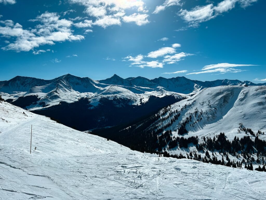 Expert territory at a ski resort with partially cloudy and blue skies above.