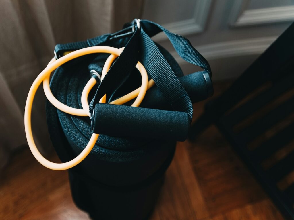 A jump rope sitting on top of a yoga mat.