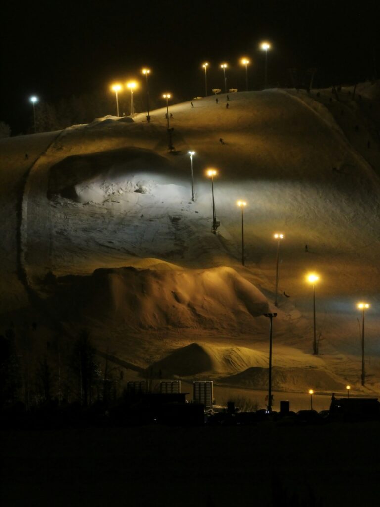 A ski slope at night lit up by lights.