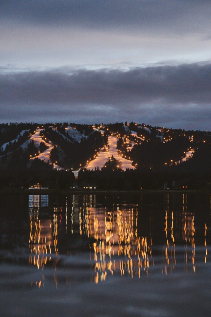 A ski resort at night lit up while skiers going down wearing the best goggles for night skiing.
