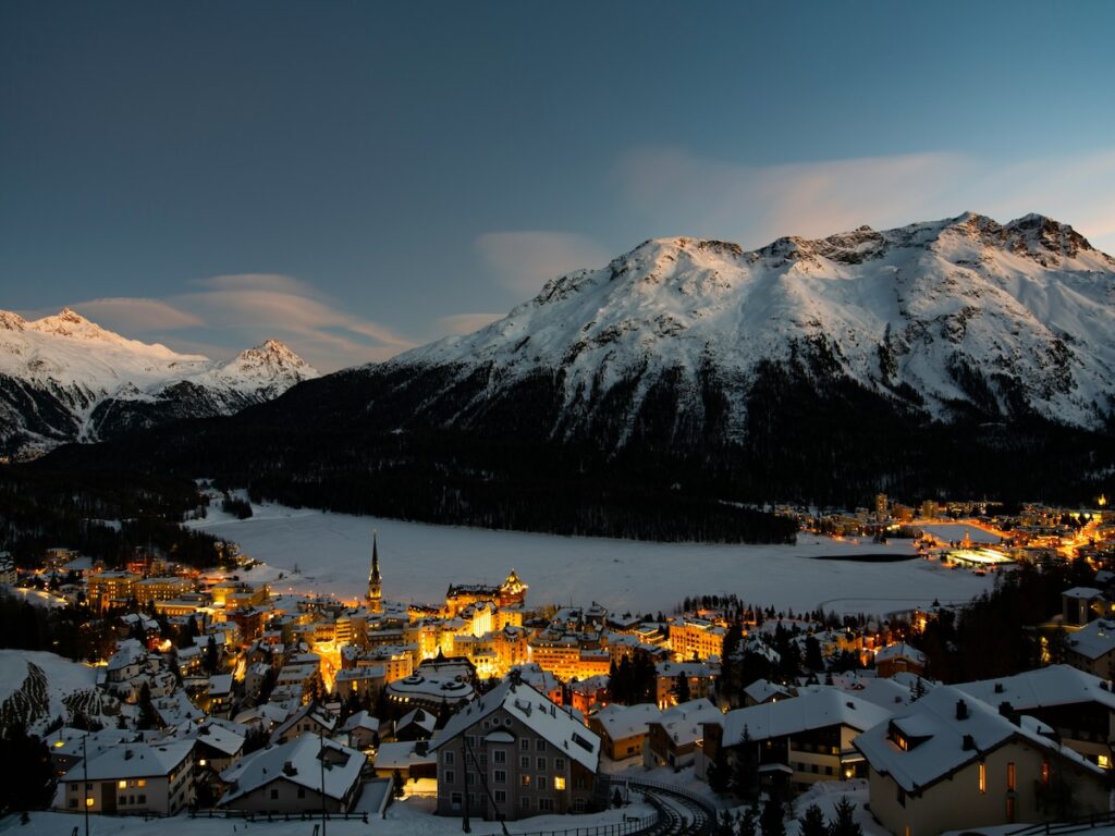 St Moritz during sunset with the towns lights shining.