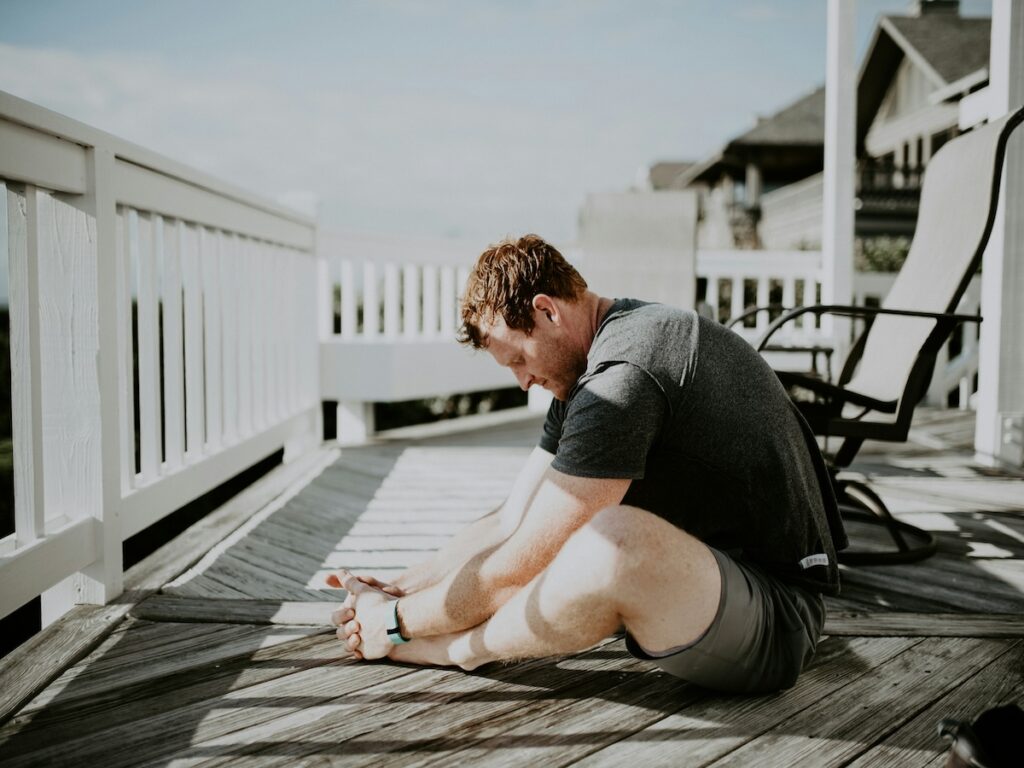 A man stretching on a deck.