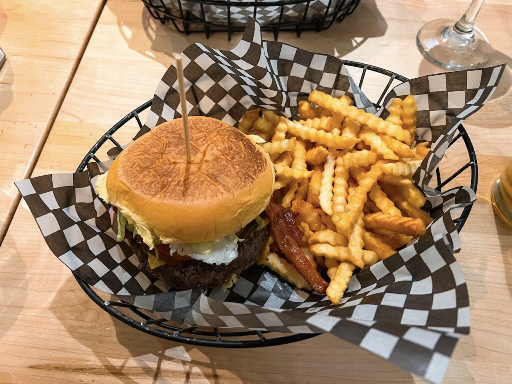 A burger and fries served in a basket.