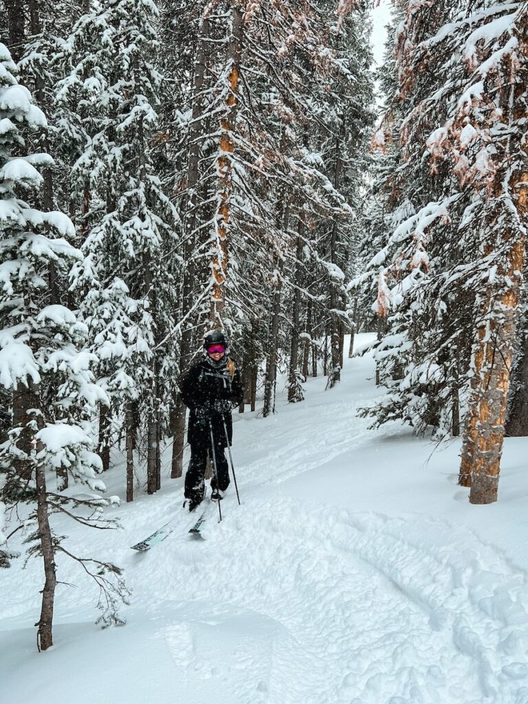 Abby skiing in powder through trees at Breckenridge.