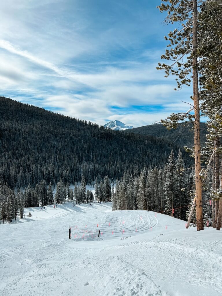 Breckenridge ski slopes with trees and a mountain top in the distance.