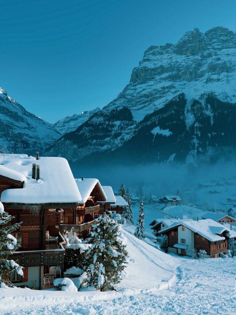 A few different mountain style Ski In Ski Out homes with mountains in the background.