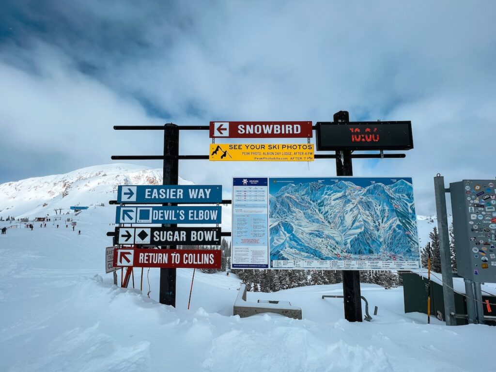 An Alta ski slope sign with a sign pointing towards Snowbird.