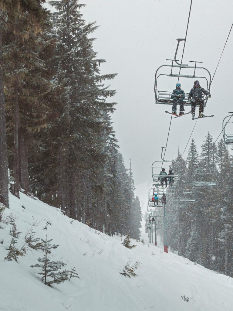 Skiers sitting on a chair lift at Crystal Mountain, one of the best places to ski in the Pacific Northwest.