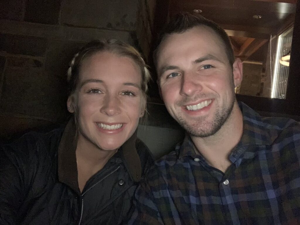 Abby and Sam smiling in Jackson Hole outside one of the best restaurants.