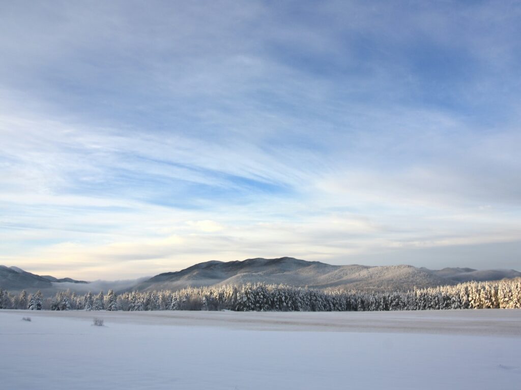 Lake Placid covered in snow and the mountains off in the distance.