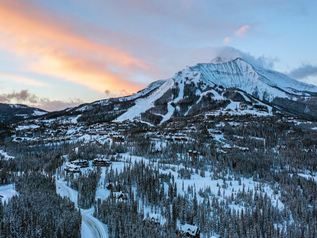 Big Sky Resort at sunset with the sky turning pink and blue.