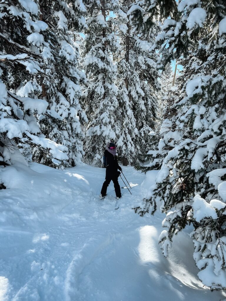 Abby skiing through trees while pregnant.