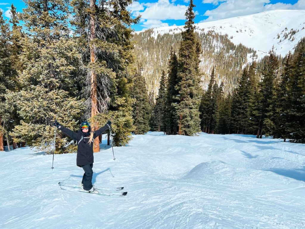 Abby smiling while skiing through the trees at Breckenridge.