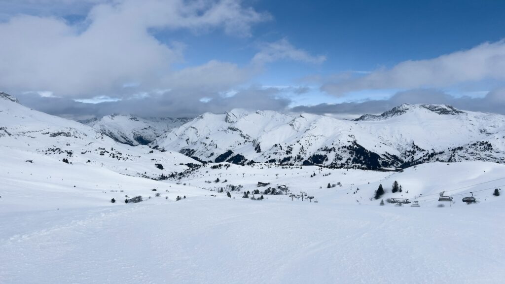 A ski resort in Austria on a partially cloudy and blue sky day.