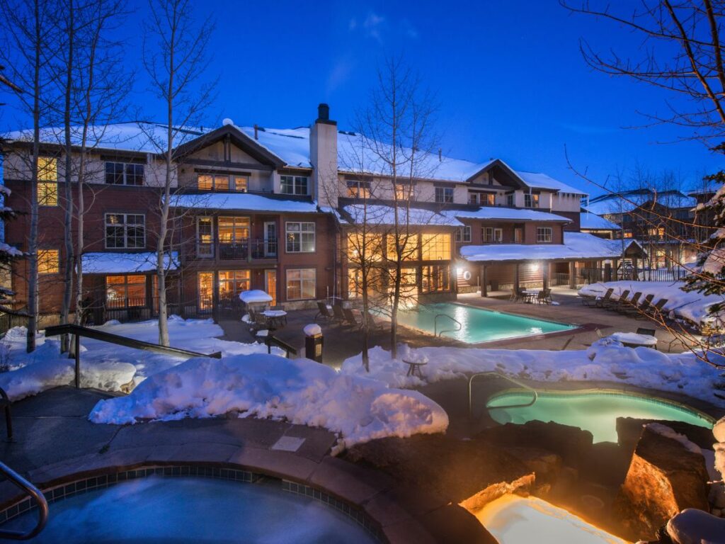 The Grand Timber Lodge's hot tubs and pool surrounded by snow.