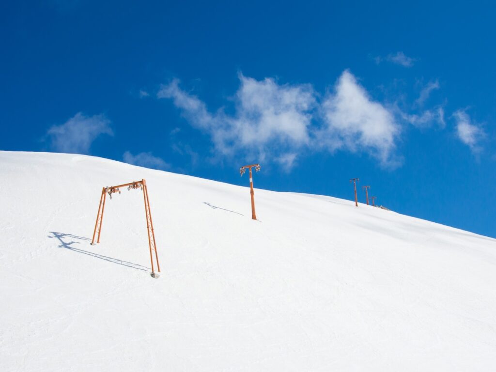 Ski slopes in Italy with partially cloudy and blue skies above.