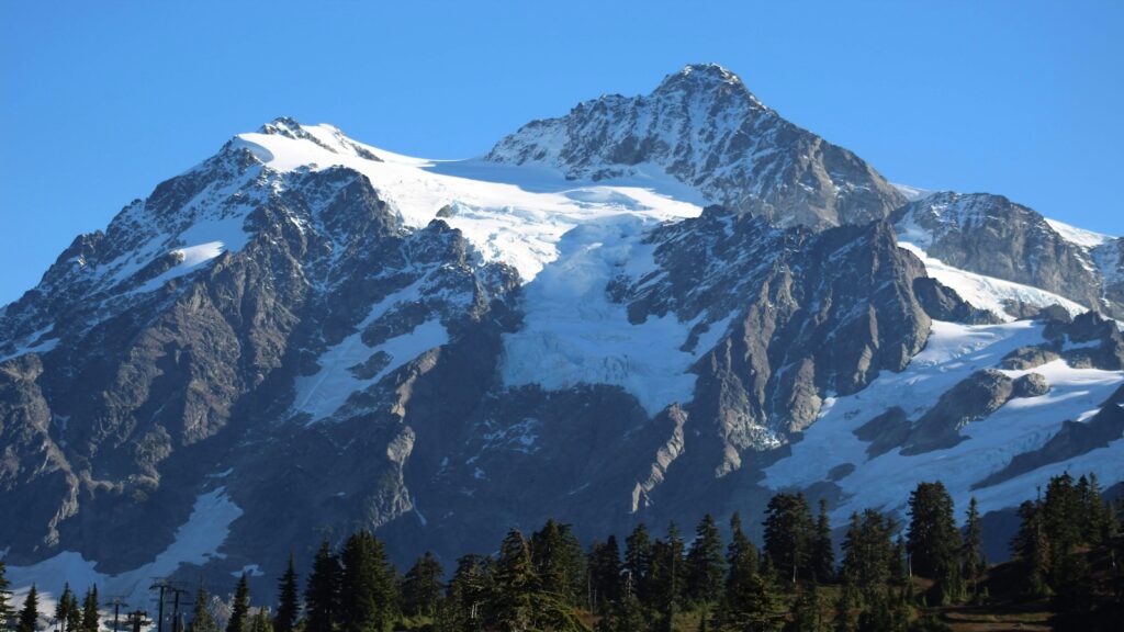 Mount Baker in Washington with blue skies above and snow on the mountain.