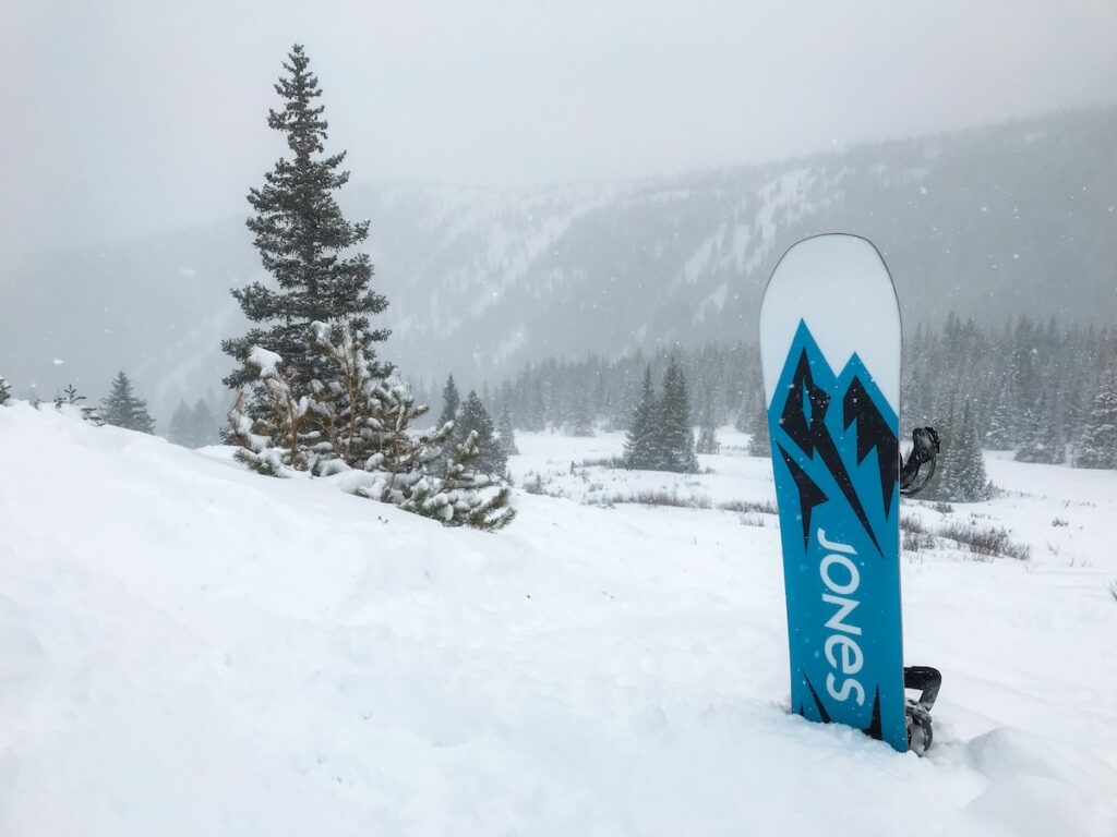 Sam's snowboard sticking out of powder at Breckenridge.