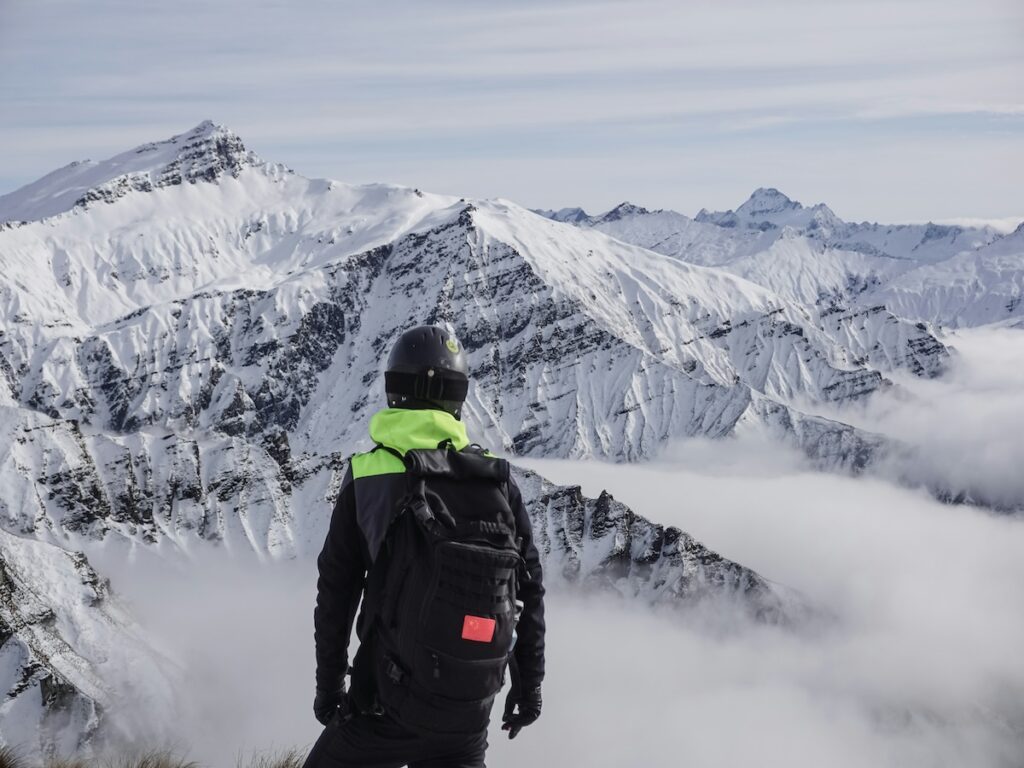 A skier looking out at snow covered mountains at Treble Cone in New Zealand.