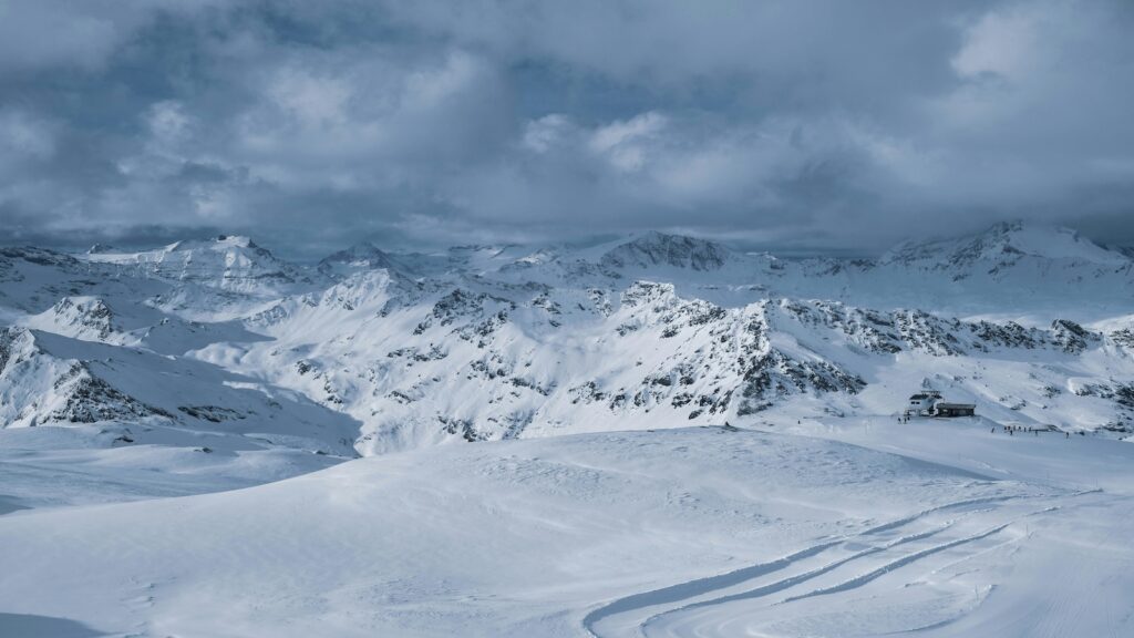 A cloudy day in the mountains while they are covered in snow.