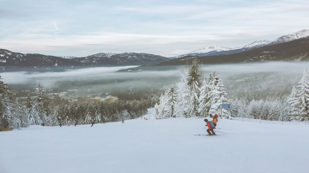 Two skiers going down the mountain at Whistler Blackcomb.