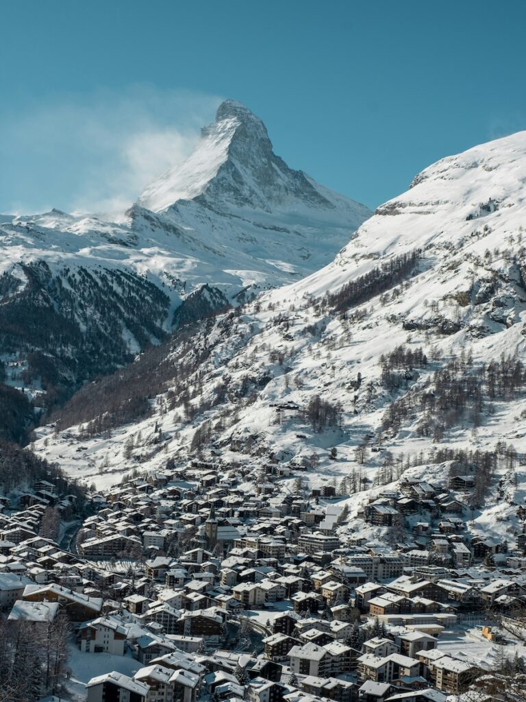 Zermatt and its town blanketed in snow on a sunny blue sky day.