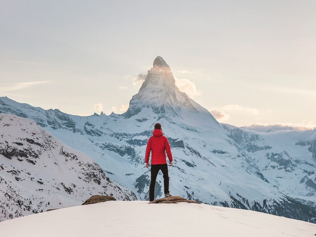 A man looking out at the Matterhorn covered in snow.