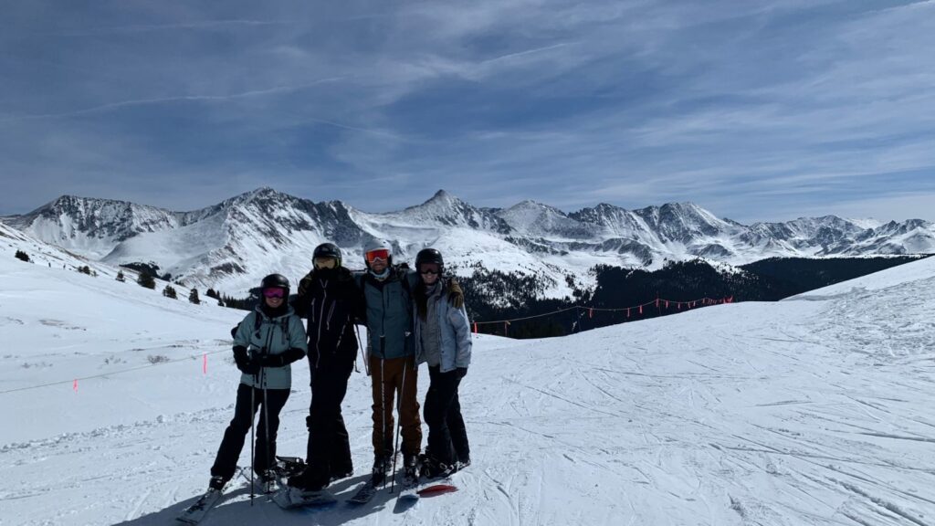 Four friends skiing and snowboarding in Colorado.