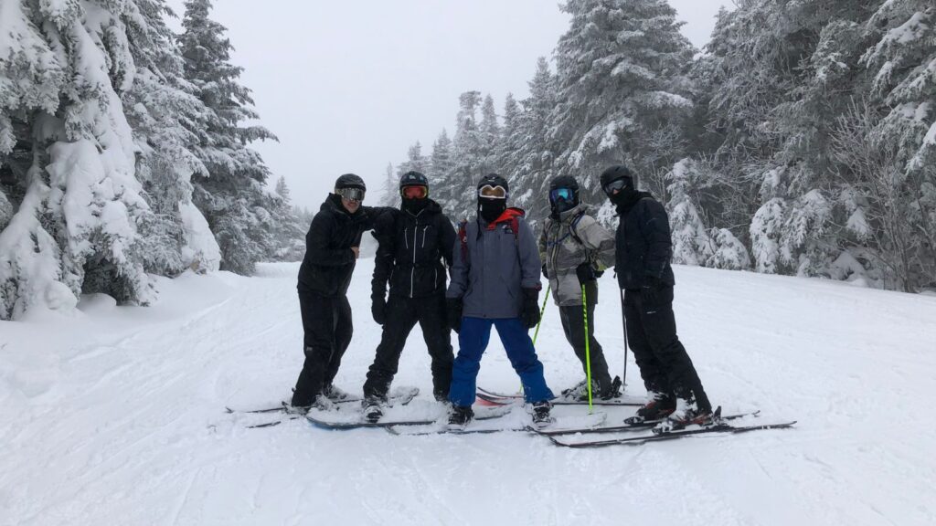 A group of friends skiing and snowboarding on a powder day.