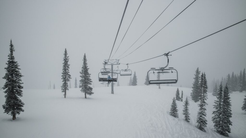 A skier by themselves on a chairlift.