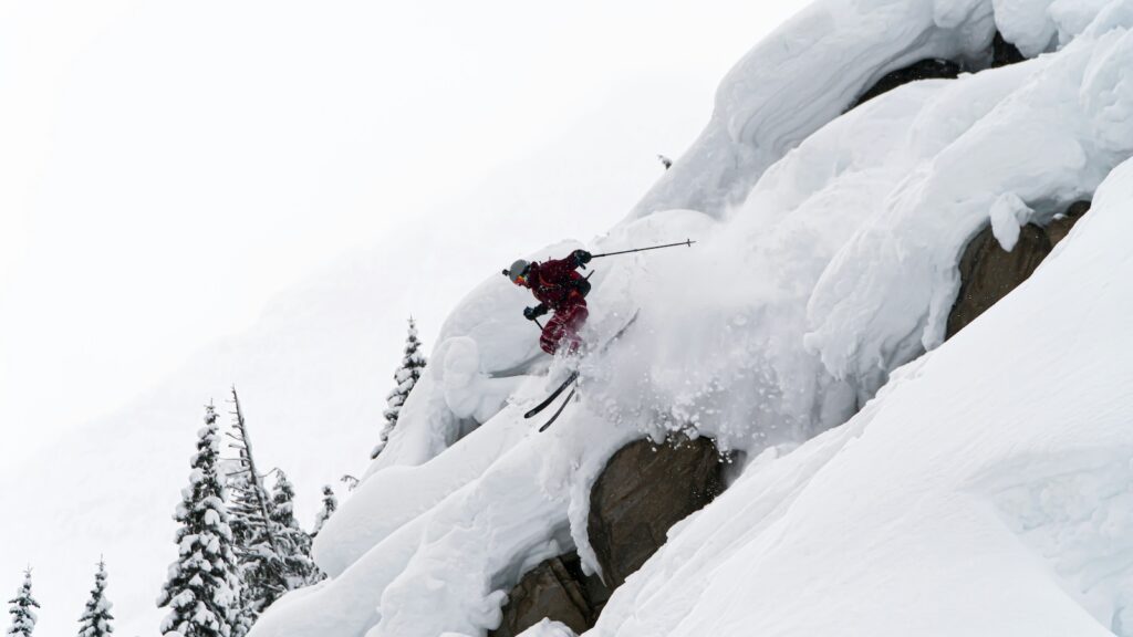 A skier jumping off a cliff at Revelstoke.