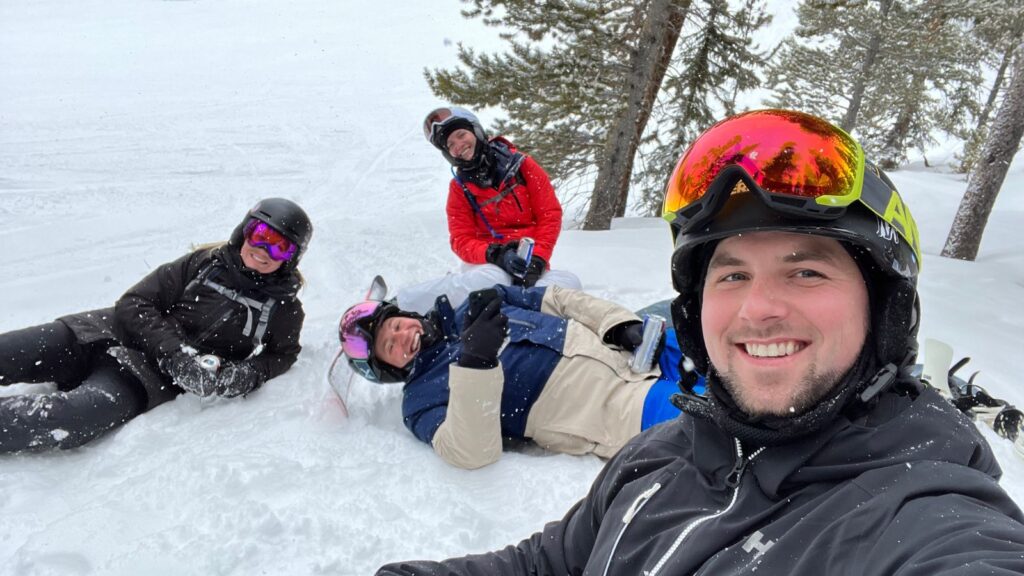 Friends sitting in the snow at a ski resort